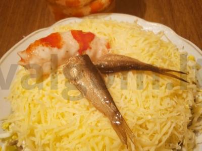 Žuvies salotos su šprotais, kiaušiniais, agurkais ir sūriu pagrindine nuotrauka