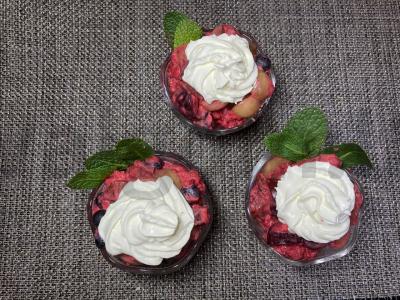 Vynuogių desertas su vaisiais, uogomis ir plakta grietinėle pagrindine nuotrauka