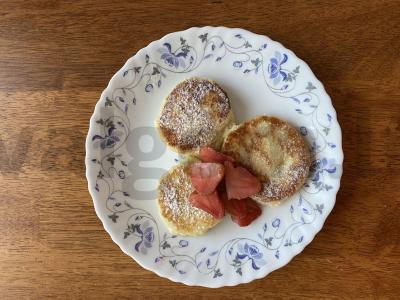 Švelnūs sūrio pyragėliai su braškėmis ir cukraus pudra pagrindine nuotrauka