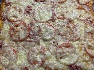 Pica ant sluoksniuoto tešlos su gaudos sūriu ir rūkytomis dešromis pagrindine nuotrauka