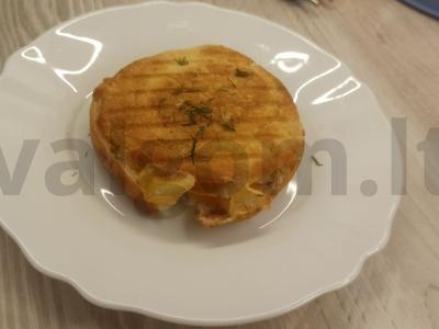 Sūrio, geltonojo pomidoro ir žolelių bandelė ant grotelių pagrindine nuotrauka