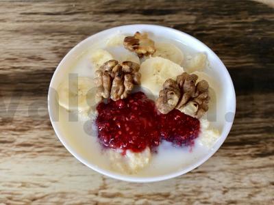 Kviečių košė su bananais, avietėmis ir graikiniais riešutais pagrindine nuotrauka