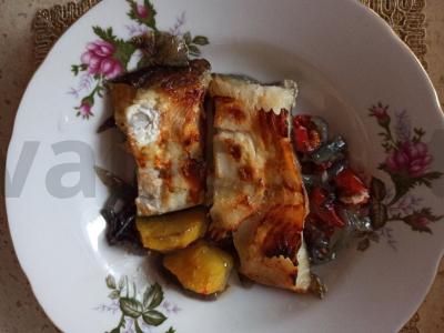 Keptas plokščiasis menkė ant svogūnų pagalvėlės su bulvėmis ir pomidorais pagrindine nuotrauka