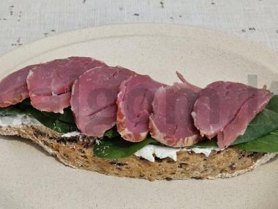 Brusketa su sūrio šonine ant baby špinatų pagrindine nuotrauka