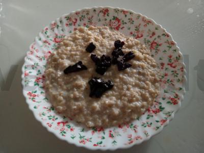 Avižinė košė su džiovintais slyvomis ir cukraus pudra pagrindine nuotrauka