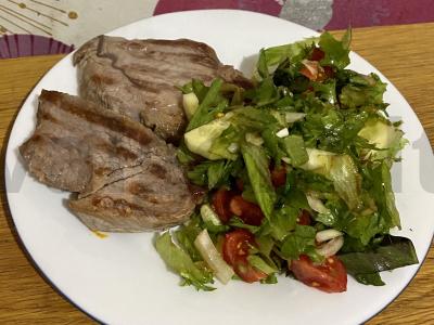 Kiaulienos steikas ant grotelių su daržovių salotomis pagrindine nuotrauka