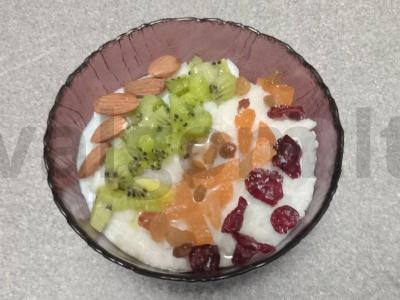 Pieninė ryžių košė su kokosų aliejumi, džiovintomis spanguolėmis, razinomis, džiovintomis abrikosais, kiviais ir migdolais pagrindine nuotrauka