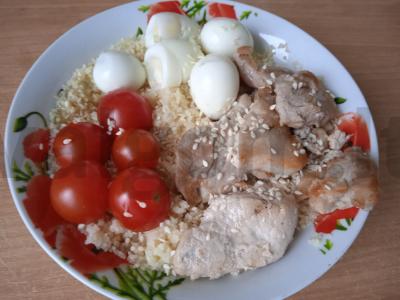 Kuskuso, kiaulienos, vyšnininių pomidorų ir putpelių kiaušinių dubuo pagrindine nuotrauka