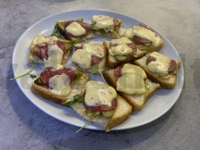 Karšti sumuštiniai su saliami, rukola ir marinuotais agurkais pagrindine nuotrauka