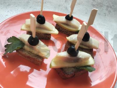 Kanarė „Laiveliai“ su obuoliu ir silke ant juodos duonos pagrindine nuotrauka