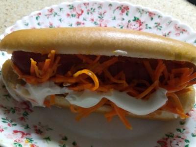 Karštas šuo su korėjietiška morkų salotomis ir pomidorais pagrindine nuotrauka