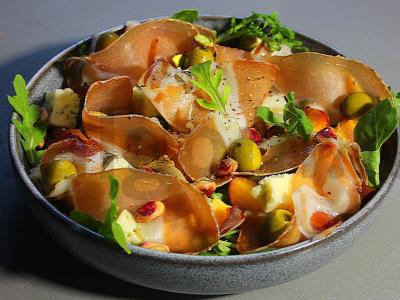 Salotas su kumpiu ir persikais prie šampano pagrindine nuotrauka