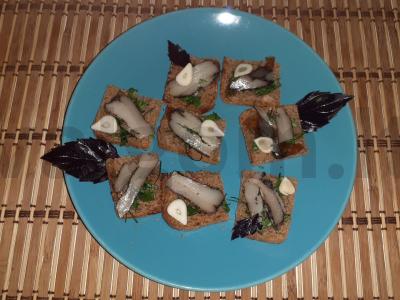 Užkandis ant ruginių skrudintų duonos riekelių su lašiniais, česnaku ir žolelėmis pagrindine nuotrauka