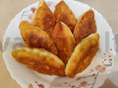 Kepti pyragėliai su kopūstais ir žuvimi ant mielinės tešlos pagrindine nuotrauka