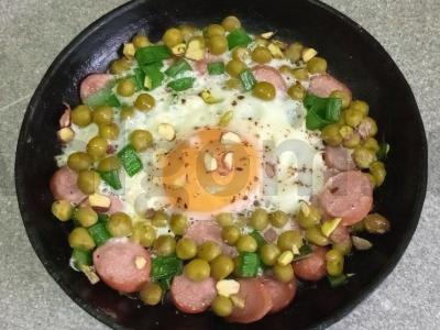 Kiaušiniai su dešra, žaliais žirneliais ir pistacijomis pusryčiams pagrindine nuotrauka