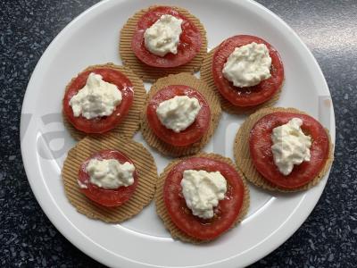 Užkandis ant krekerių su pomidorais, sūriu ir česnaku pagrindine nuotrauka