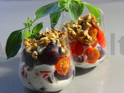 Slyvų, pomidorų ir graikinių riešutų salotas taurėje pagrindine nuotrauka