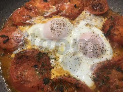 Kiaušiniai shakšuka su pomidorais, svogūnais ir prieskoniais pagrindine nuotrauka