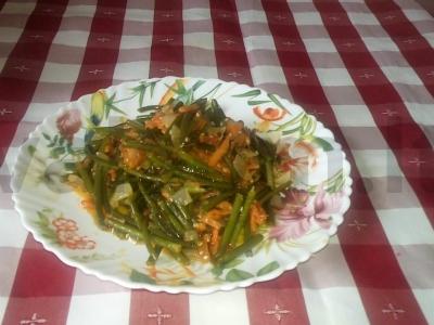 Šiltas salotas iš česnako stiebų, morkų ir svogūnų pagrindine nuotrauka